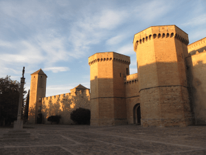 El sol reflejado en las torres de la muralla de Poblet