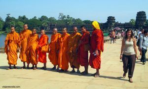 Lorena pasando junto a unos monjes que posaban en la entrada al templo de Angkor Wat