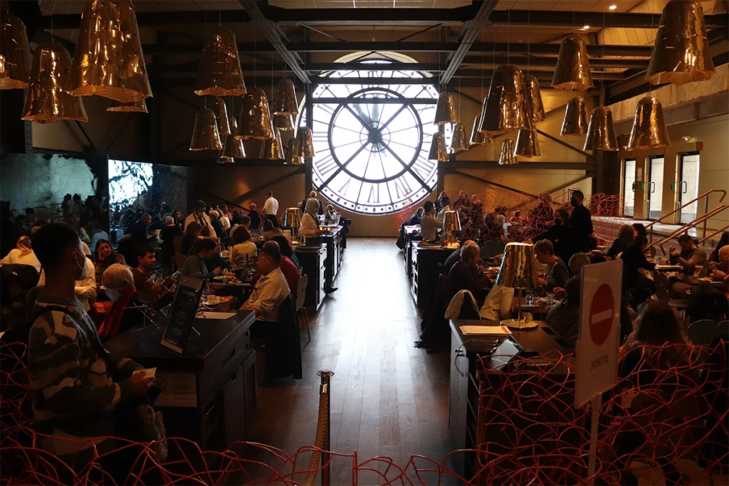 Restaurante del museo parisino con un gran reloj en la fachada