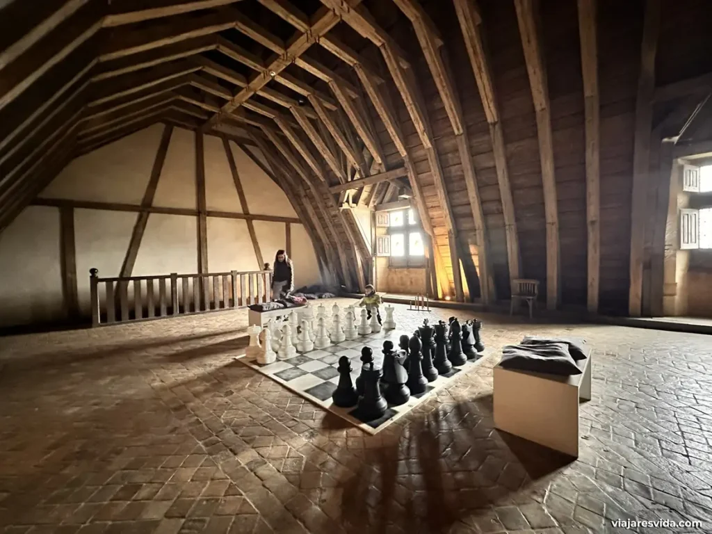 El desván medieval de madera del castillo con un ajedrez gigante